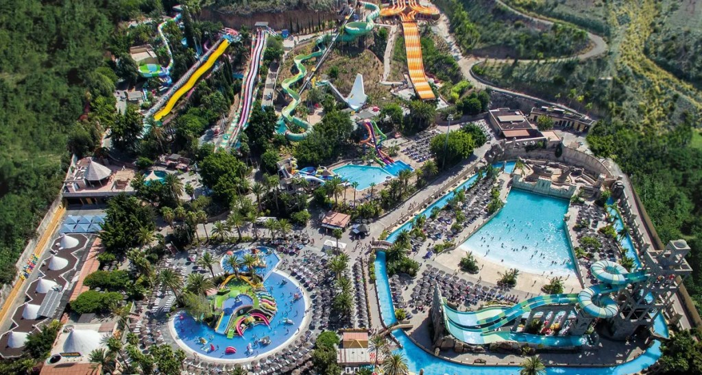Aerial view of Aqualand, a water park in Gran Canaria, featuring colorful slides, pools, and tropical landscaping.