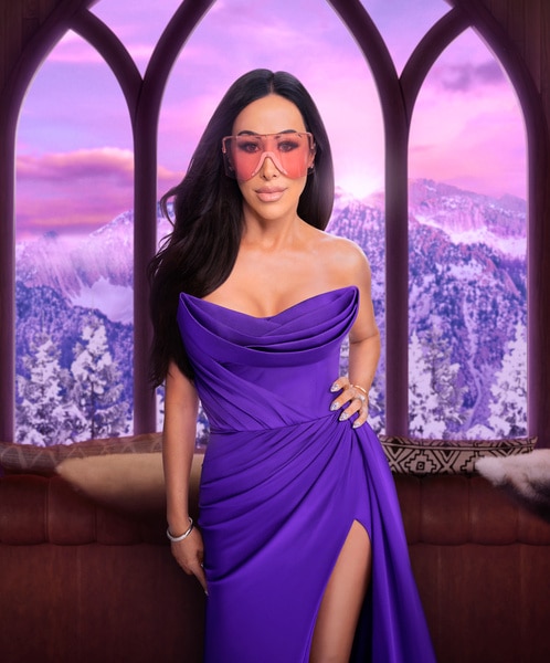 Angie Katsanevas wearing a purple gown in a wooded living room overlooking a snowy mountain